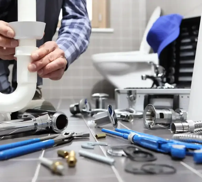 Plombier lors d'une intervention raccordement sanitaires, Leon-services