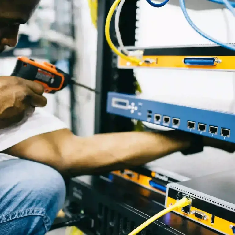 Électricien certifié et expérimenté Technicien travaillant sur un équipement réseau avec des câbles et des outils dans le 94