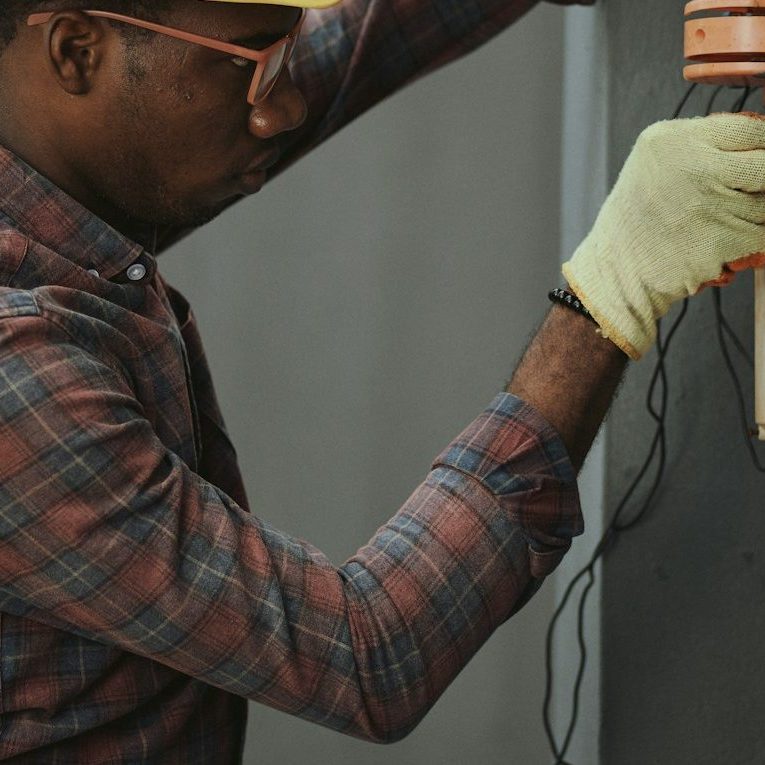 Intervention électrique pour éviter les courts-circuits Électricien coupant un fil électrique pour prévenir les courts-circuits et les surcharges